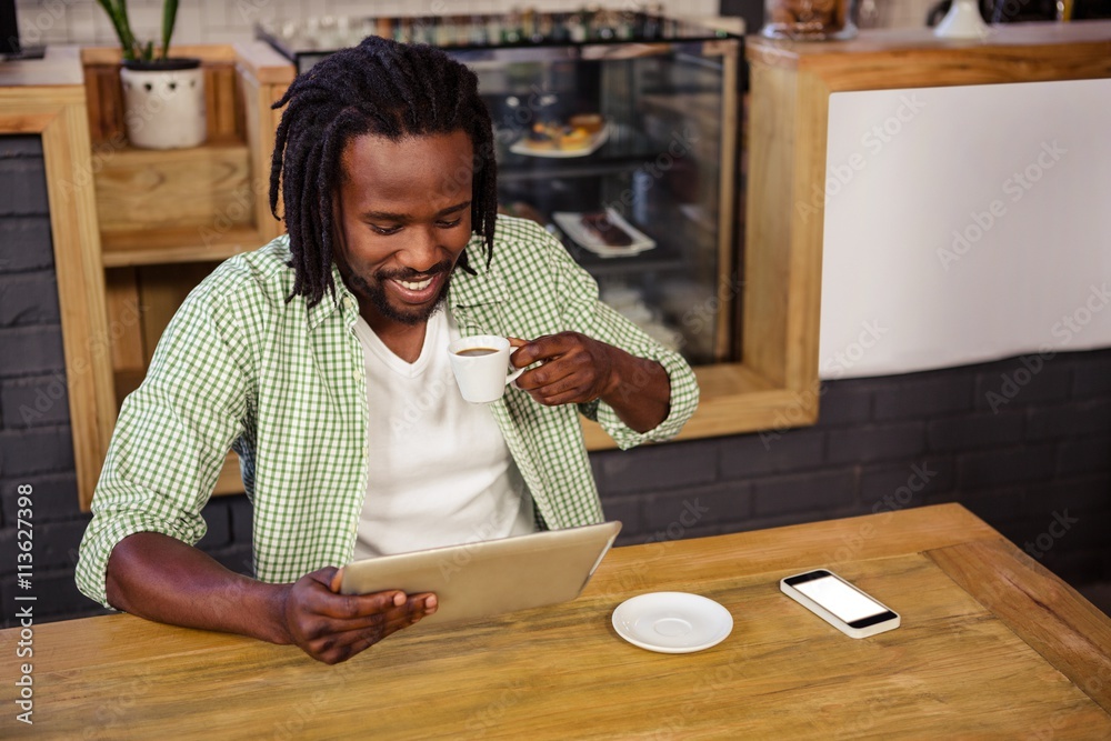 Poster man drinking coffee and using tablet