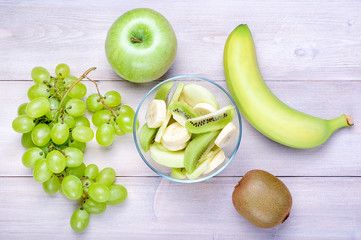 Salad of green fruits: apple, banana, grapes and kiwi