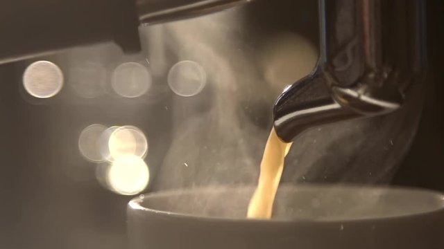 Coffee flows from cofee machine in slow motion