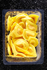 plastic pack of fresh ravioli on a dark background