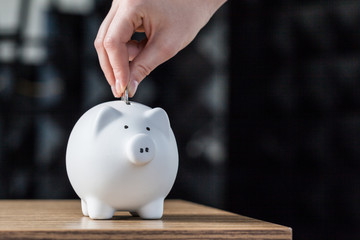 Inserting a coin into a piggy bank
