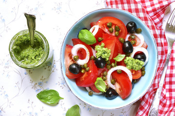 Tomato salad with capers,black olives,onion and sauce pesto.