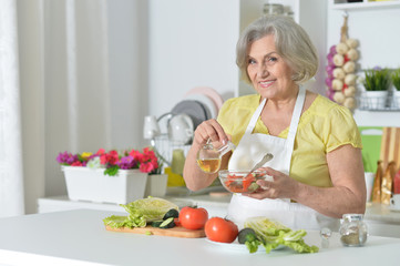 Obraz na płótnie Canvas Senior woman cooking in kitchen