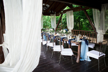 Wedding restaurant decor, rustic, boho style. Glasses, a wooden table, a blue tablecloth.