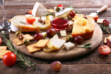 Different kinds of cheese on wooden background