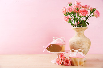 Mother Day concept. Roses with cupcake on pink background