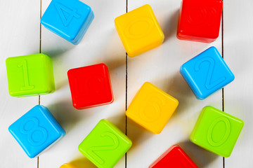 Colorful children's cubes on white wooden background