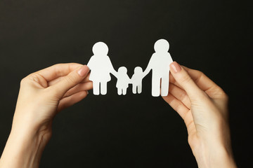 Fototapeta na wymiar Woman hands holding wooden family shape. Love and relationships concept