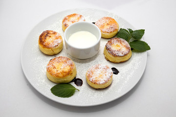 Cheese biscuits with cream and mint on the plate on white background