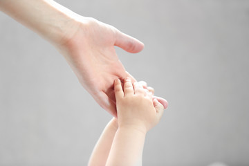 Woman holding small baby hand