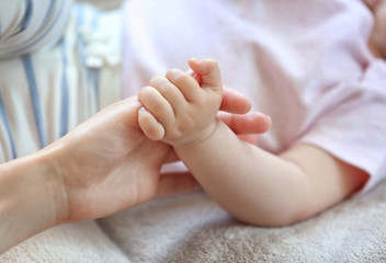 Obraz na płótnie Canvas Woman holding small baby hand