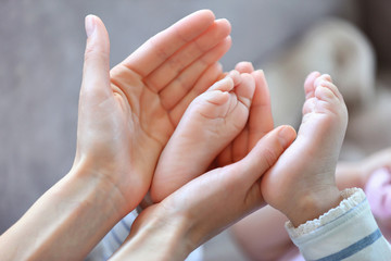 Woman holding small baby foot