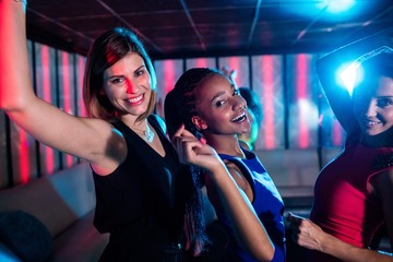 Smiling friends dancing on dance floor