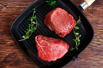 Fresh Raw Beef steak Mignon with thyme on grilled pan
