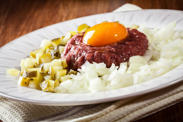 Steak tartare with egg yolk, onions and pickles