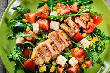 Fresh salad with chicken breast, arugula and tomato