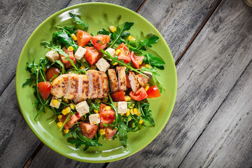 Fresh salad with chicken breast, arugula and tomato