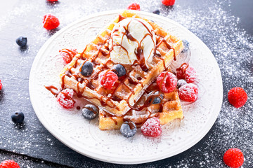 Belgian waffles with ice cream, chocolate sauce and fresh berries.