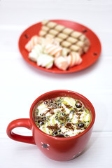 Hot cocoa with marshmallow and cinnamon on wooden table