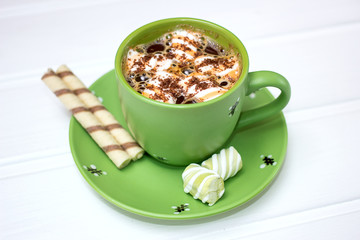 Hot cocoa with marshmallow and cinnamon on wooden table