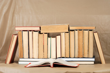 Stack of hardback books on brown leather. Back to school. Copy space