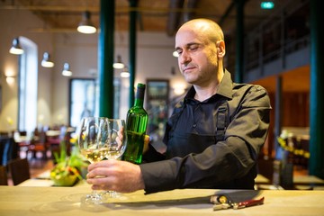 Waiter holding glasses and a bottle of white wine