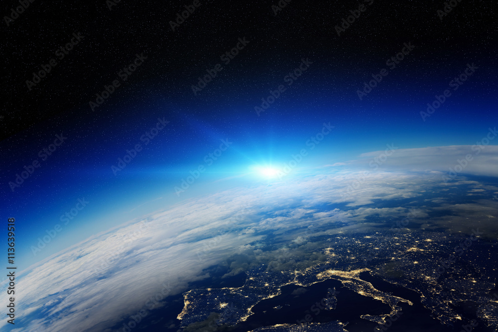 Wall mural sunrise over planet earth in space