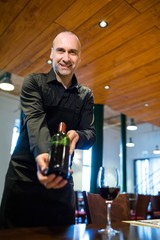 Waiter holding a bottle of red wine