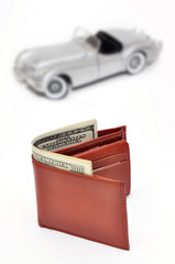 Wallet with US Dollars on blured Toy car background