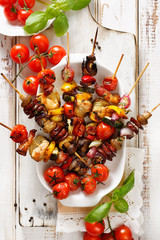 Various grilled skewers of vegetables and meat in a herb marinade on white plate, top view © zi3000