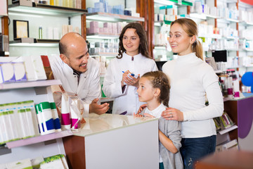 Obraz premium Mother with a girl in the pharmaceutical store