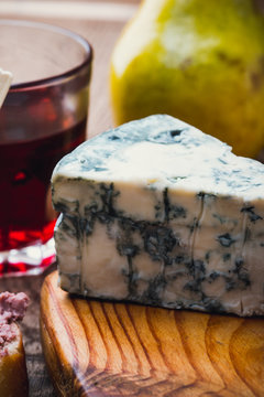 Blue cheese with red wine on wooden board