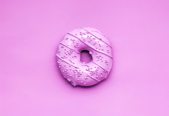 Pink glaze / Creative photo of a painted pink donut on pink background.