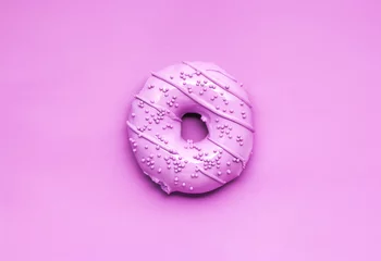 Gordijnen Pink glaze / Creative photo of a painted pink donut on pink background. © Sasha_Brazhnik