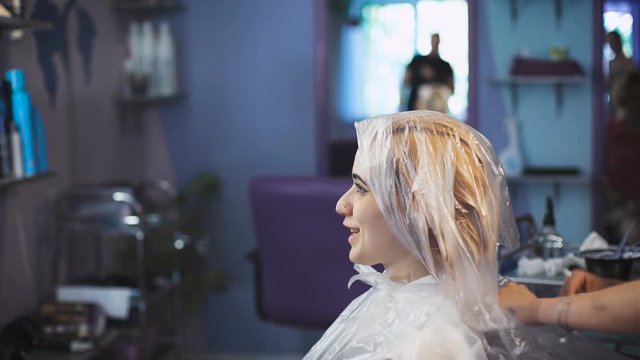 stylist hairdresser does a professional paint on the hair of his client.