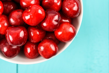 White Bowl Of Fresh Red Cherries On Turquoise Background