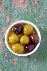 olives in a bowl on wooden surface