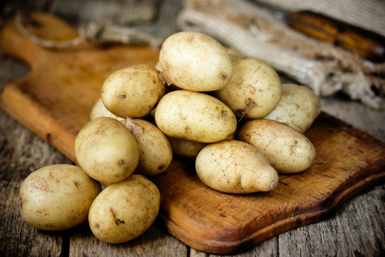 Raw potato food. Fresh young potatoes in old rustic wooden background