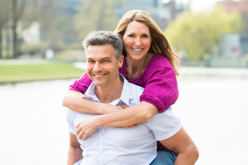 Naklejka premium Happy Man Piggybacking His Wife