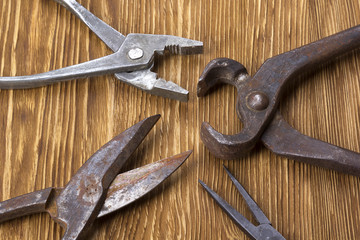 Heap of old instruments on wooden background. Pliers and scissors.