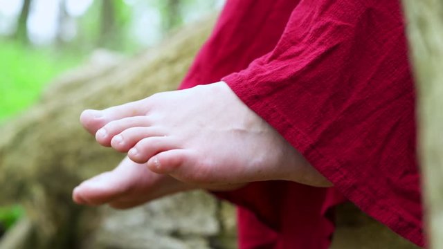 Feet of young female girl wiggling in nature.