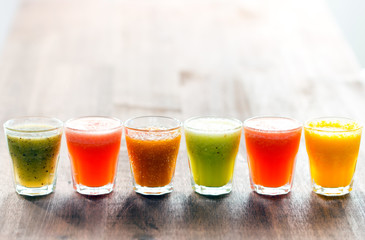 Set of fruit smoothie and juice in glasses on wooden background with a lot of copy space for your text or editing