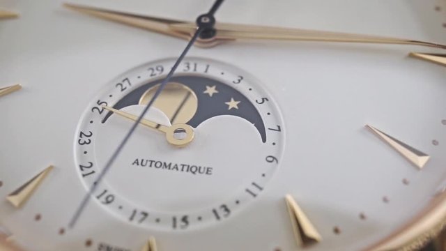 Expensive golden wrist watch with lunar phase indicator, macro dolly video