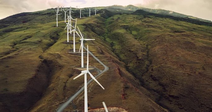 Aerial view of windmills turning at sunset, wind power turbines generate clean renewable energy
