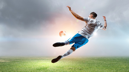 Obraz na płótnie Canvas Soccer player hitting ball