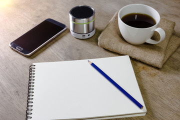 note book with coffee pencil speaker and smartphone on desktop