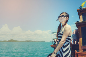 Asian woman relaxing on cruise with sunny day.