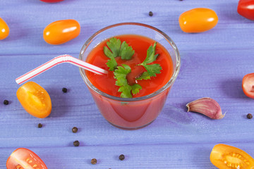 Tomato juice and vegetables with spices on purple board, healthy nutrition