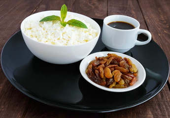 Fresh homemade cottage cheese, golden raisins and a cup of coffee. A healthy breakfast.