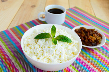 Fresh homemade cottage cheese, golden raisins and a cup of coffee. A healthy breakfast.